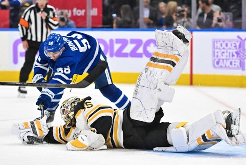 Boston Bruins goalie Linus Ullmark dives to reach a loose puck ahead of Maple Leafs' Michael Bunting in the second period at Scotiabank Arena on Saturday, Nov. 5, 2022. 