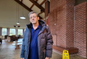 Marvin Lund stands in the common room at 501 Queen St., a publicly-owned seniors housing complex. Rain on Nov. 7 brought renewed flooding to the common area after post-tropical storm Fiona caused roof damage to the building. Stu Neatby • The Guardian