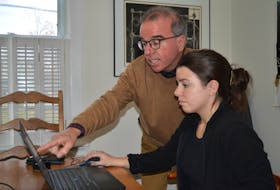 Charlottetown mayoral candidate Philip Brown, left, goes over some numbers on the computer with his daughter, Emma Louise Brown, at their home on Nov. 7. Brown is the incumbent and is aiming at a second term as mayor of Charlottetown. Dave Stewart • The Guardian