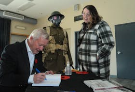 Retired school principal and teacher and long-time Signal Hill Tattoo director and Royal Newfoundland Regiment advisory board member, Maj. Jim Lynch, held a book signing on Saturday, Nov. 5, 2022. His book "Trench Warfare: the Exploits of the Royal Newfoundland Regiment in the Trenches of Gallipoli, France and Flanders" takes a close look at the conditions the soldiers endured during the long hours in the trenches. He signs a copy for former Tattoo member Kelsie Puddister. Joe Gibbons/The Telegram/SaltWire Network