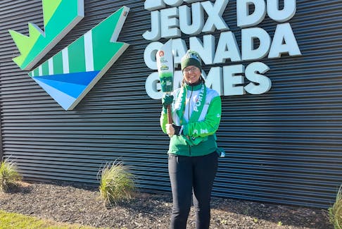 SaltWire Network's Alison Jenkins hoists the flame at the Canada Games Torch Relay in Summerside Nov. 8. Contributed.