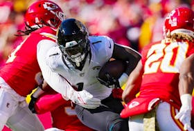 Travis Etienne Jr. of the Jacksonville Jaguars is tackled by Mike Danna of the Kansas City Chiefs	during the first half of the game at Arrowhead Stadium on November 13, 2022 in Kansas City, Missouri.