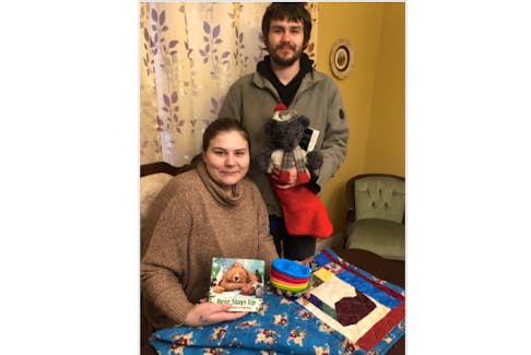 Kayla Meade and Elijah Grosvold, whose son was stillborn, are filling a Christmas stocking for another child in their son’s memory. In the foreground is a small quilt they received from the palliative care unit at Aberdeen Hospital.