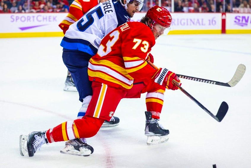 Calgary Flames right-wing Tyler Toffoli and Winnipeg Jets centre Mark Scheifele vie for the puck during the third period at the Scotiabank Saddledome in Calgary on Nov. 12, 2022.