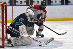Tyson Boland of the Glace Bay Panthers, right, looks to get the loose puck in the crease before Auburn Drive Eagles goaltender Devan Gillett during action at the Panther Classic high school hockey tournament at Miners Forum on Friday. Auburn Drive won the game 5-4. JEREMY FRASER/CAPE BRETON POST.