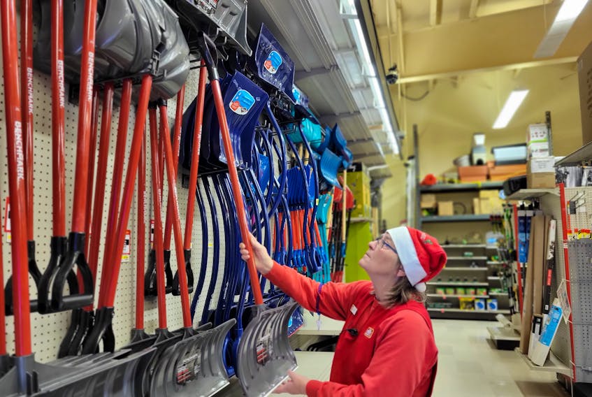 Debbie Burns, a seasonal clerk at Home Hardware on St. Peters Rd. in Charlottetown, sets up a display of shovels on Dec. 12. Charlottetown is bracing for its first significant storm of the season on Dec. 13. Stu Neatby • The Guardian