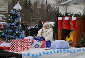 A lady and her dog atop a float.