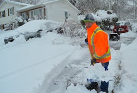 Vince Clifford of Cottage Road shovels his driveway as he notices dangling phone lines outside his home on Tuesday. IAN NATHANSON/CAPE BRETON POST