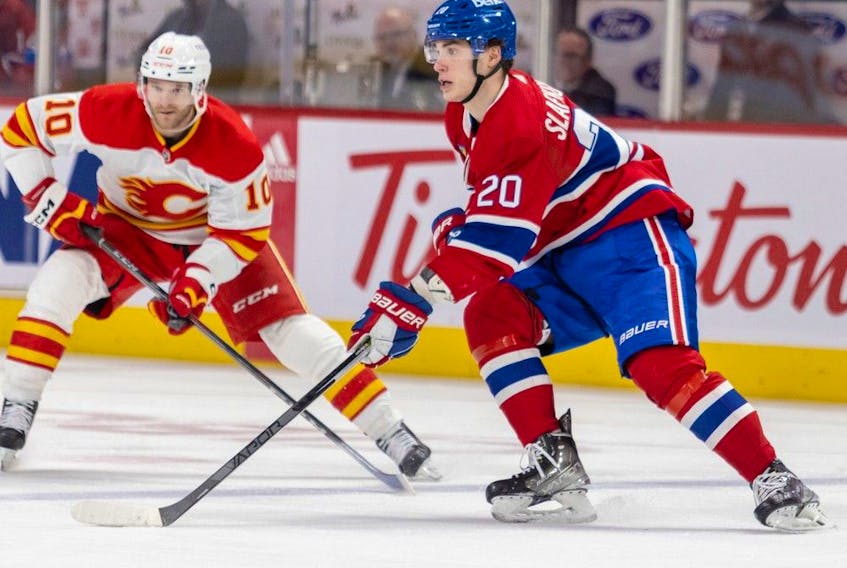 Canadiens' Juraj Slafkovsky looks to make a pass in front of Flames' Jonathan Huberdeau during third period Monday night at the Bell Centre.