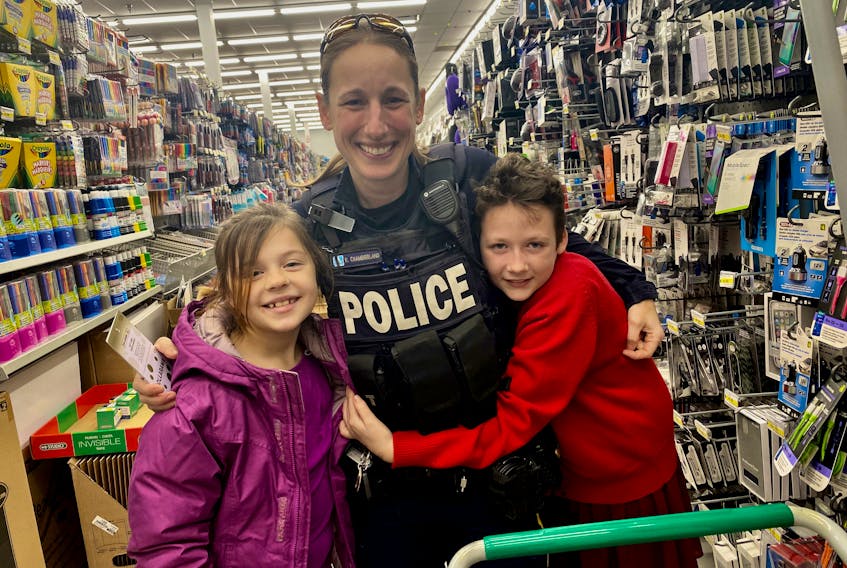 RCMP Const. Roxane Chamberland helped Yarmouth Elementary School students Ava Doucet and Jaylyn Doucette with shopping for their families at Dollarama as part of a recent Cop Shop excursion involving members of the RCMP and some elementary students from the school. TINA COMEAU PHOTO