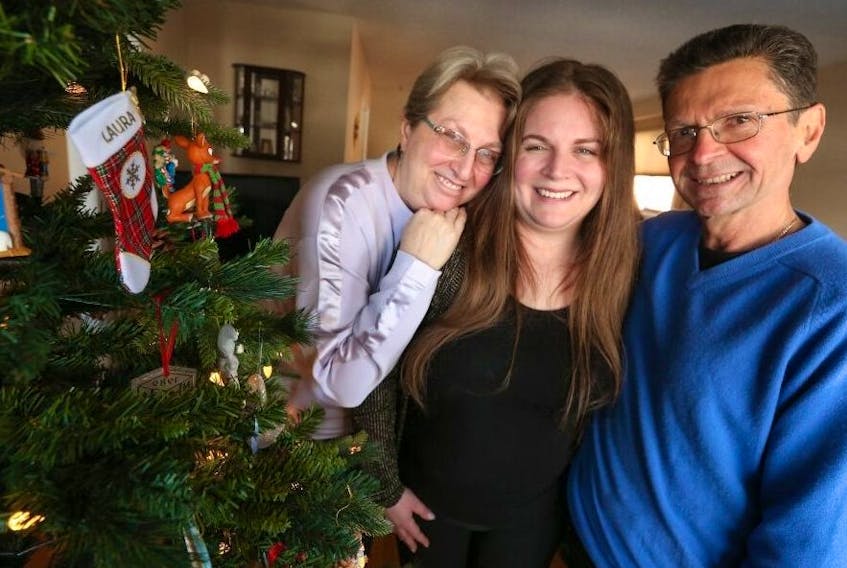 Laura Gambino, centre, is pictured with her parents, Anna and Al, next to the family's Christmas tree, Dec. 13, 2022.