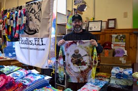 Terry Betts hols up one of his original, tie-dyed designs at the annual Artisan Christmas Market hosted by the Charlottetown Farmer's Market Co-operative Dec. 11. The special seasonal market will run again Dec. 18. Alison Jenkins • The Guardian