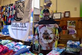 Terry Betts hols up one of his original, tie-dyed designs at the annual Artisan Christmas Market hosted by the Charlottetown Farmer's Market Co-operative Dec. 11. The special seasonal market will run again Dec. 18. Alison Jenkins • The Guardian