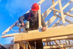 Joe Boland, a second-year carpenter apprentice, framing the front gable of a roof. He says his workplace promotes a learning culture where he feels supported. PHOTO CREDIT: Nova Scotia Apprenticeship Agency.