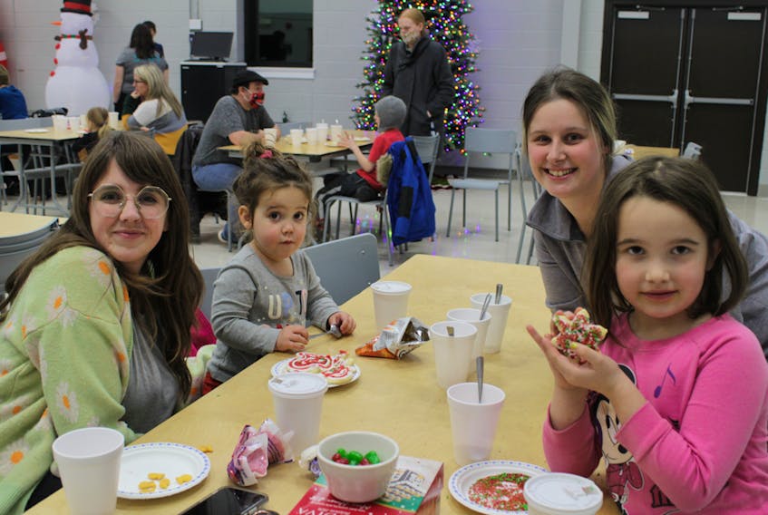 Danielle Chaplin (left), her two children, Violet and Alex, and Haley Smith decorating cookies.