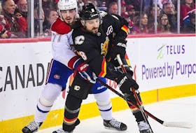 Christopher Tanev #8 of the Calgary Flames chases the puck against Kirby Dach #77 of the Montreal Canadiens during the first period of an NHL game at Scotiabank Saddledome on December 1, 2022 in Calgary, Alberta, Canada. (Photo by Derek Leung/Getty Images)