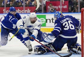 Tampa Bay Lightning left wing Nicholas Paul falls towards Toronto Maple Leafs goaltender Jack Campbell as Maple Leafs centre Colin Blackwell defends during third period NHL first-round playoff series action in Toronto on Saturday, May 14, 2022.