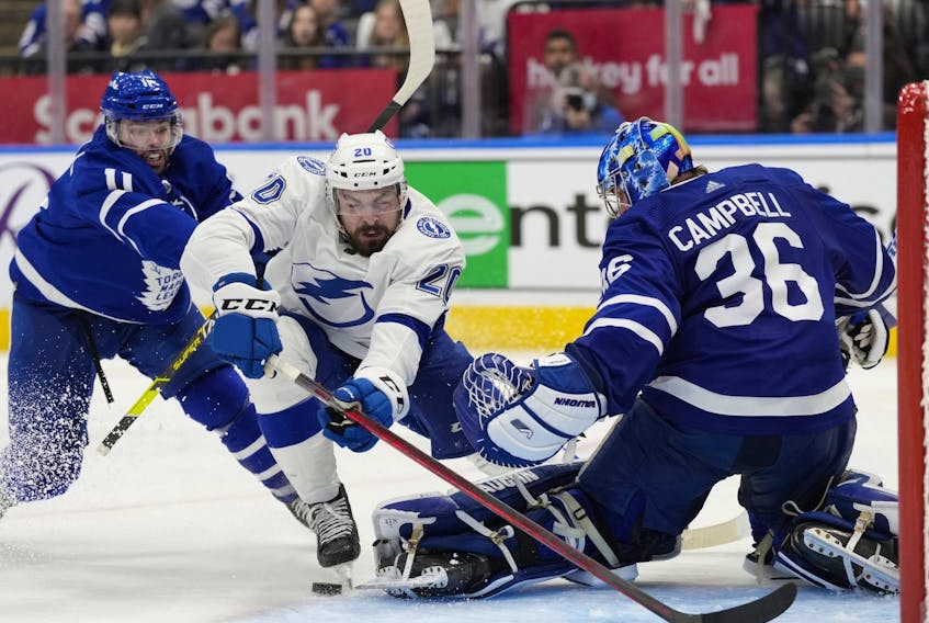 Tampa Bay Lightning left wing Nicholas Paul falls towards Toronto Maple Leafs goaltender Jack Campbell as Maple Leafs centre Colin Blackwell defends during third period NHL first-round playoff series action in Toronto on Saturday, May 14, 2022.