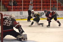 In this file photo, Ethan Stanwick of the Eskasoni Eagles, middle, gets a shot on goal as he's slashed by Bailey MacDonald of the Membertou Jr. Miners, right, during Nova Scotia Junior Hockey League action at the Membertou Sport and Wellness Centre. The rivalry between Eskasoni and Membertou will continue tonight when the two teams meet at 7:30 p.m. at the Membertou Sport and Wellness Centre. JEREMY FRASER/CAPE BRETON POST.