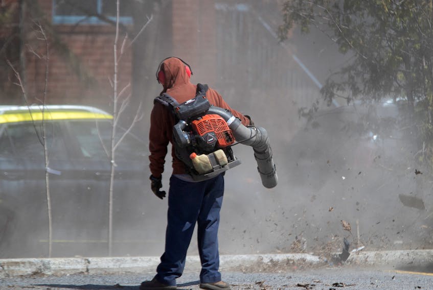 MONTREAL, QUE.: April 24, 2020 -- A landscaping crew creates a huge cloud of dirt and debris as they use gas powered leaf blowers to clean the Atwater Market parking lot, blowing the winter season’s mess on to the street for city workers to collect, in Montreal, on Friday, April 24, 2020. (Allen McInnis / MONTREAL GAZETTE) ORG XMIT: 64