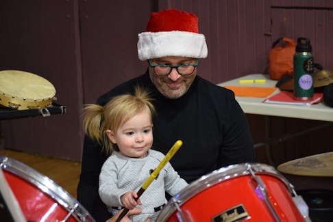 Wren Stoddard, 20 months, from Kentville, and her dad, Michael Stoddard, take a few minutes before the Four Seasons Community Orchestra’s Christmas concert to warm up on the drums. Wren was at the concert to support her father and grandmother, Ellen Crowley, who both play percussion.