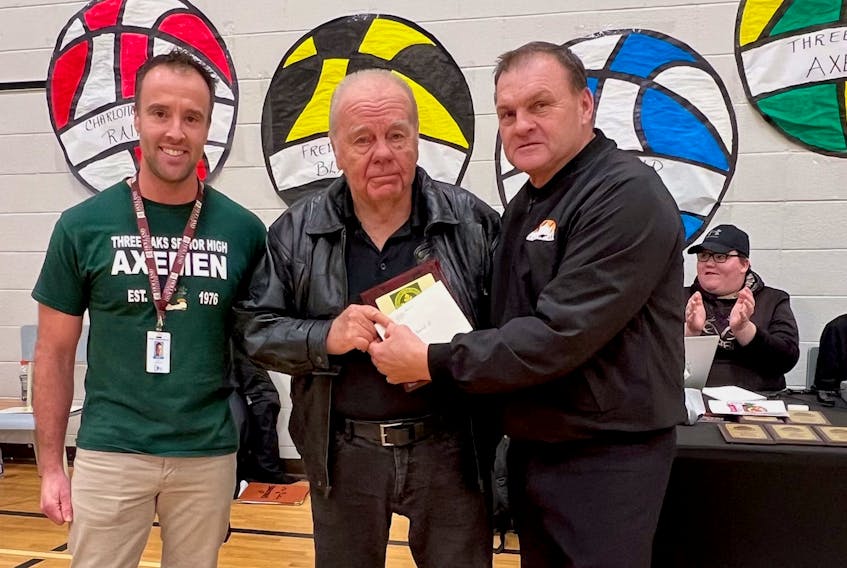 Three Oaks Senior High School in Summerside honoured Darryl Gaudet, who served as the official scorer for basketball games there for 20 years. Gaudet stepped down from the role for the 2022-23 season. Three Oaks athletic director Joel Arsenault, left, and P.E.I. Basketball Officials Association (PEIBOA) member Dale Farish, right, made a presentation to Gaudet during the recent Three Oaks ADL Christmas Classic senior AAA boys’ tournament.
