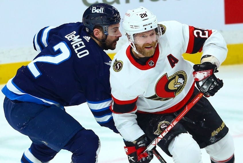 Ottawa Senators forward Claude Giroux (right) is impeded by Winnipeg Jets defenceman Dylan DeMelo in Winnipeg on on Tuesday night.