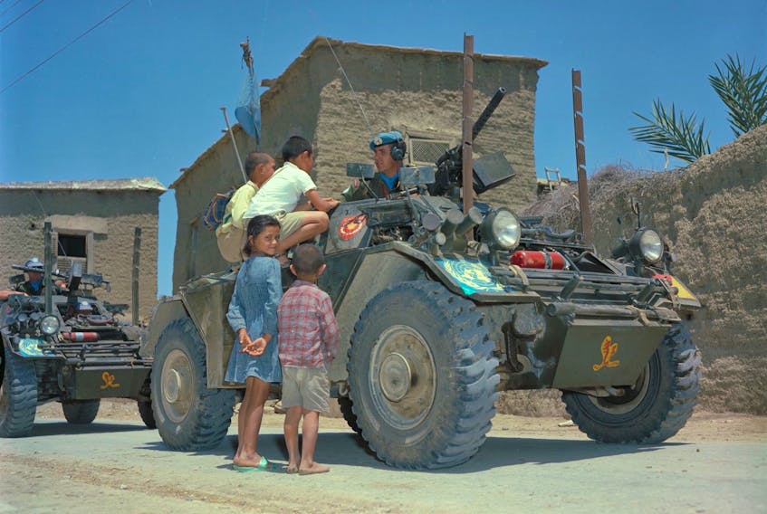 A Canadian Peacekeeper speaks with local children in Cyprus in 1965. Simon LeMay recalls being far from home when he served as a Peacekeeper in Sinai and asks readers to think of soldiers during the holiday season.Department of National Defence ZK-2057-4