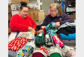 Christmas Wishes volunteers Amber Sawh, left, and Linda McCormick sort through gifts for the program that serves Springhill residents ages 17 and older and strives to make sure everyone has something under the tree on Christmas morning. DARRELL COLE