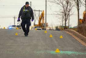 A Halifax Regional Police officer collects evidence at a shooting scene on Cutler Avenue in Dartmouth on Thursday, Dec. 22, 2022. A man was taken to hospital with what are believed to be non-life-threatening injuries. - Ryan Taplin