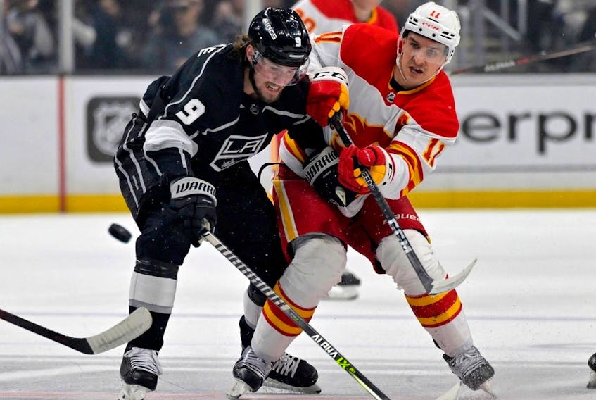  Calgary Flames forward Mikael Backlund and Los Angeles Kings forward Adrian Kempe battle for the puck at Crypto.com Arena in Los Angeles on Thursday, Dec. 22, 2022.