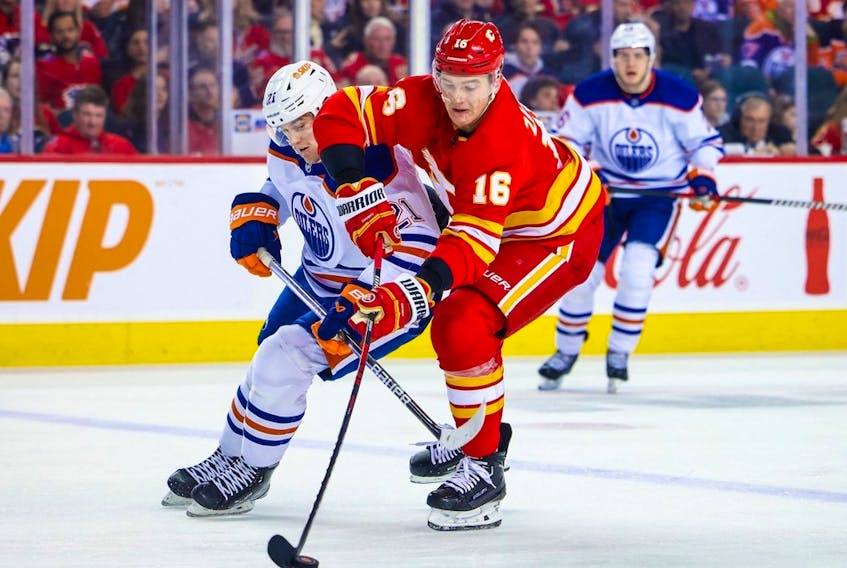 Calgary Flames defenseman Nikita Zadorov (16) and Edmonton Oilers center Klim Kostin (21) battle for the puck during the first period at Scotiabank Saddledome on Dec. 27, 2022. 