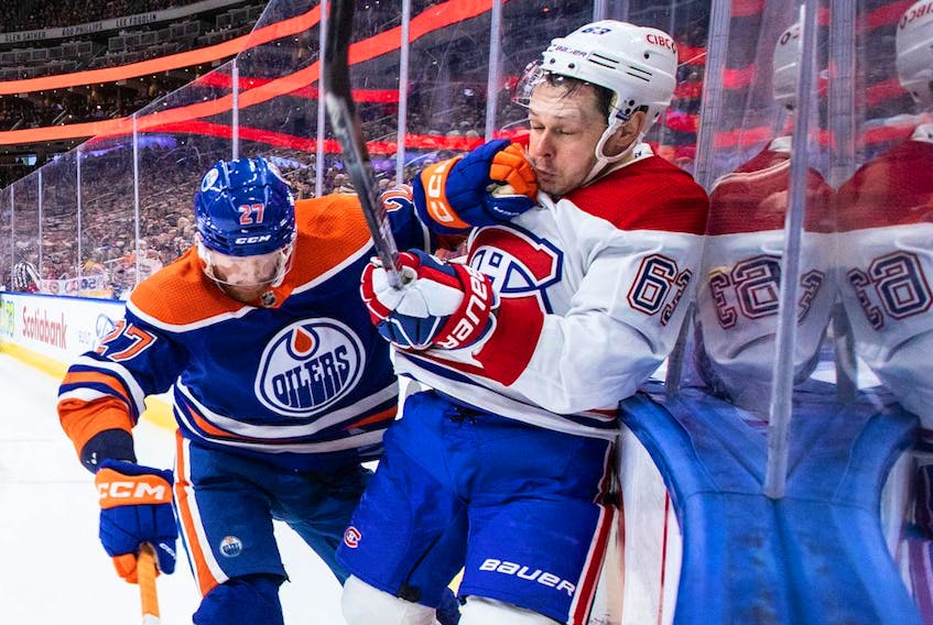 Canadiens' Evgenii Dadonov (63) is checked by Edmonton Oilers' Brett Kulak (27) during first period NHL action in Edmonton on Saturday, Dec. 3, 2022.