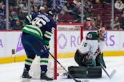 Arizona Coyotes goalie Karel Vejmelka, right, of the Czech Republic, allows a goal to Vancouver Canucks' Bo Horvat, not seen, as Andrei Kuzmenko, of Russia, watches during the first period of an NHL hockey game in Vancouver, on Saturday, December 3, 2022.