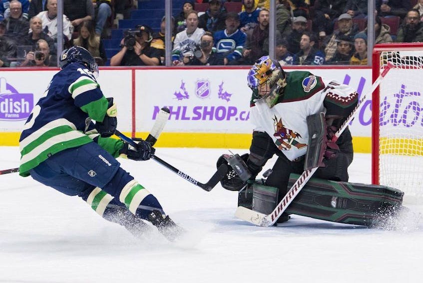  Arizona Coyotes goalie Karel Vejmelka (70) makes a save against Vancouver Canucks forward Sheldon Dries (15) in the first period at Rogers Arena Dec. 3, 2022.