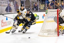 Charlottetown Islanders forward Lucas Romeo, 17, and Victoriaville Tigres defenceman Thomas Belzile, 21, race for the puck during a Quebec Major Junior Hockey League (QMJHL) game at Eastlink Centre on Dec. 2. The Tigres won the game 4-1.  Charlottetown Islanders photo