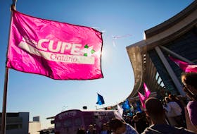 A person holds a flag with the logo of the Canadian Union for Public Employees (CUPE), during a protest about labour disputes at the Toronto Pearson International Airport in 2011.