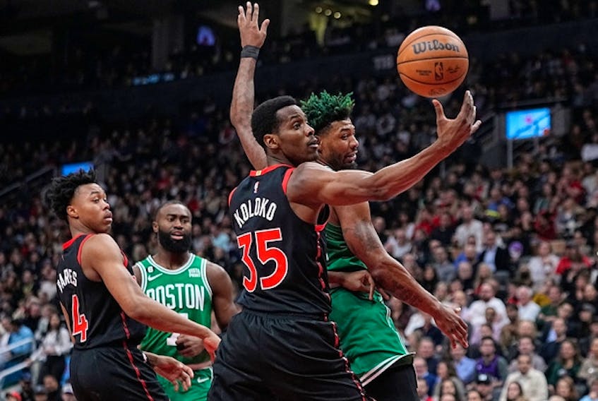 Raptors' Christian Koloko comes down with a rebound against Boston Celtics' Marcus Smart during the first half at Scotiabank Arena on Monday, Dec. 5, 2022. 