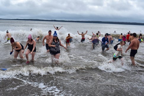 Some of the more than 75 participants of the eighth annual Port Morien Polar Dip take the icy plunge into the frosty waters of the Cape Breton fishing village’s sheltered harbour in this file photo. This year the event will celebrate it's 10-year anniversary. File