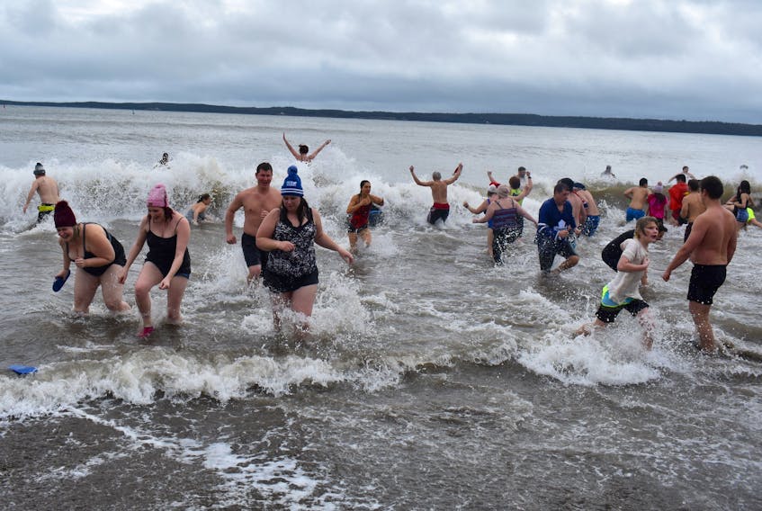 Some of the more than 75 participants of the eighth annual Port Morien Polar Dip take the icy plunge into the frosty waters of the Cape Breton fishing village’s sheltered harbour in this file photo. This year the event will celebrate it's 10-year anniversary. File