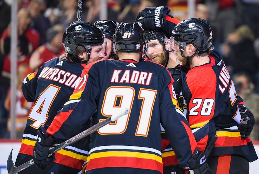 The Calgary Flames celebrate a goal during a 3-2 win over the Arizona Coyotes at the Scotiabank Saddledome in Calgary on Monday, Dec. 5, 2022. 