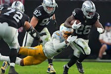 Las Vegas Raiders running back Josh Jacobs carries the ball against Los Angeles Chargers safety Derwin James Jr. in the second half at Allegiant Stadium.  