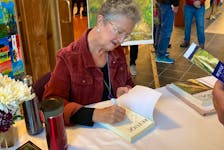 Susan Surette-Draper signed multiple copies of Refuge at the book launch in late October. WENDY ELLIOTT