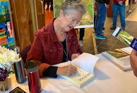 Susan Surette-Draper signed multiple copies of Refuge at the book launch in late October. WENDY ELLIOTT