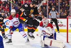 Elias Lindholm of the Calgary Flames jumps to get out of the way of a shot on Montreal Canadiens' Jake Allen during the third period at the Scotiabank Saddledome in Calgary on Dec. 1, 2022.