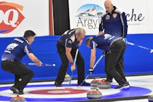 Nova Scotia skip Glen MacLeod, right looks on as Stuart MacLean and Peter Neily sweep a shot by Craig Burgess in Championship Pool play against New Brunswick on Thursday afternoon at the Mariners Centre in Yarmouth. MacLeod won the game 7-5. 