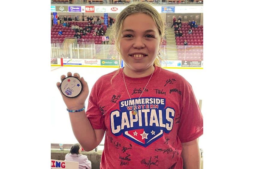Summerside D. Alex MacDonald Ford Western Capitals’ fan Grace Armsworthy of Crapaud displays a puck autographed by her favourite player, Isaac Wilson, and sports a T-shirt autographed by members of the 2022-23 team. The Caps recently hosted Grace and her family at a Maritime Junior Hockey League (MHL) game at the Island Petroleum Energy Centre. - Margaret Armsworthy/Special to SaltWire Network