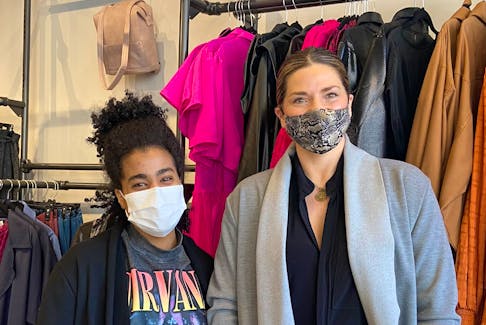 Julia Campbell, right, co-owner of Jems Boutique, and Bianca Garcia, social media lead and senior sales associate, stand near a rack of clothing at Jems Boutique on Queen Street in Charlottetown. They're getting ready to present the first P.E.I. Fashion Week.