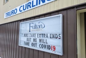 A sign outside the Truro Curling Club reads, "It may take extra ends, but we will take out COVID-19."