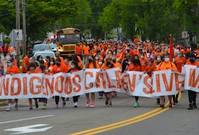 Close to 2000 people wearing orange shirts joined a walk in Sydney this past Canada Day to show support for residential school survivors and victims. FILE